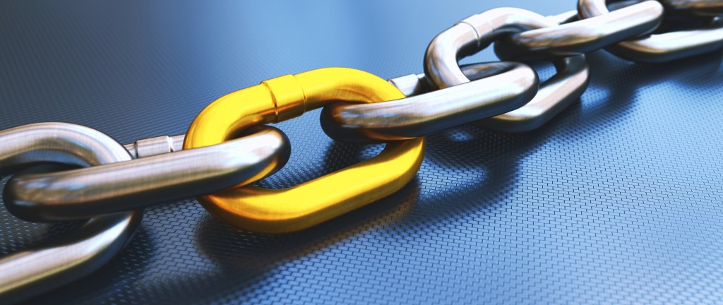 A picture of a chain, where all links are silver, except one, which is gold.